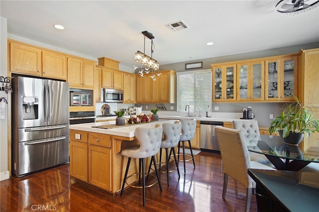 2983 Orchid Ln, Turlock, CA 95382 - kitchen with appliances with stainless steel finishes, a center island, dark wood-style flooring, glass insert cabinets, and recessed lighting