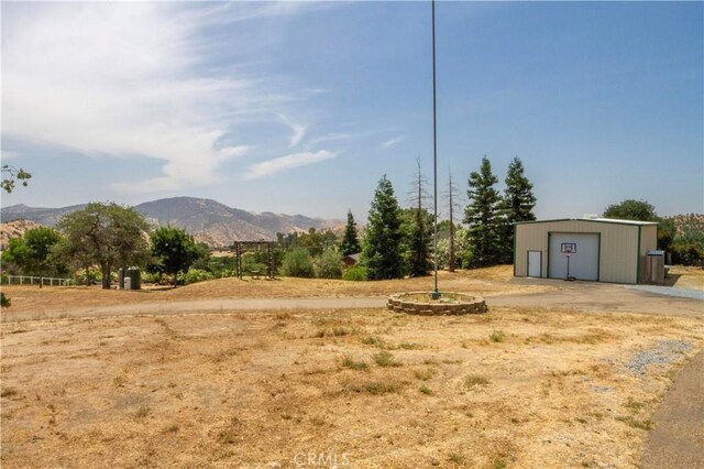 33708 Bronco Ln, Squaw Valley, CA 93675 - view of yard featuring driveway, a mountain view, a detached garage, and an outbuilding