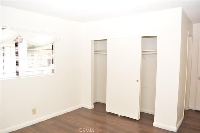 15351 Orange Ave Unit 25, Paramount, CA 90723 - unfurnished bedroom featuring dark wood-style flooring, a closet, and baseboards