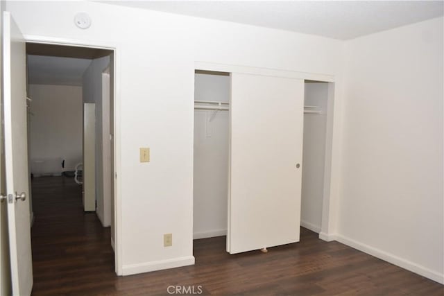 15351 Orange Ave Unit 25, Paramount, CA 90723 - unfurnished bedroom with dark wood-style flooring, a closet, and baseboards