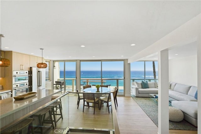 11938 Whitewater Ln, Malibu, CA 90265 - dining space featuring floor to ceiling windows, healthy amount of natural light, a water view, light wood-type flooring, and recessed lighting
