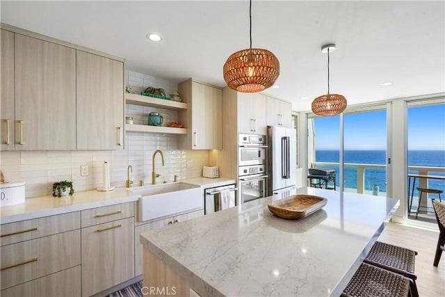 11938 Whitewater Ln, Malibu, CA 90265 - kitchen featuring a sink, a kitchen breakfast bar, appliances with stainless steel finishes, decorative backsplash, and modern cabinets