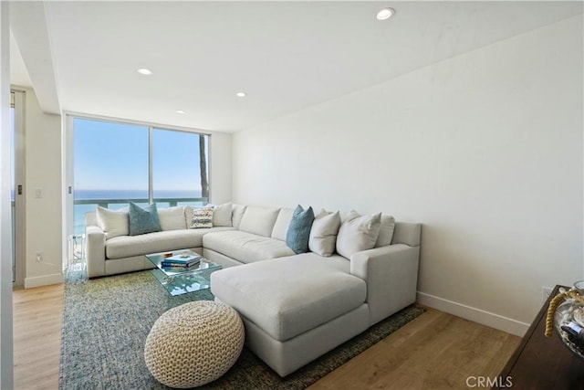 11938 Whitewater Ln, Malibu, CA 90265 - living room with light wood-style floors, baseboards, recessed lighting, a water view, and a wall of windows