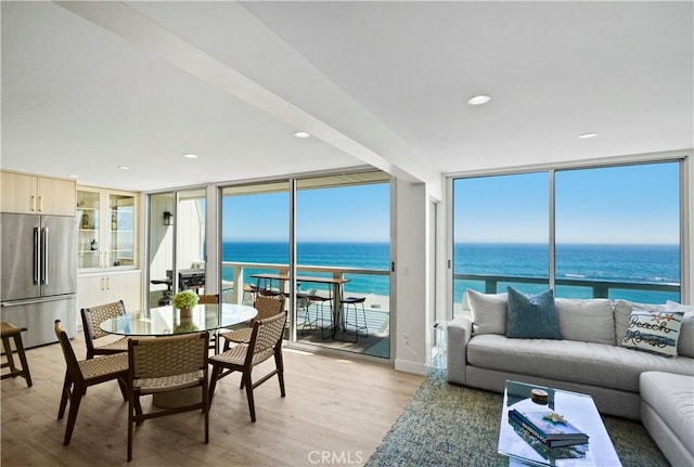 11938 Whitewater Ln, Malibu, CA 90265 - dining area featuring floor to ceiling windows, light wood-style floors, a water view, and recessed lighting