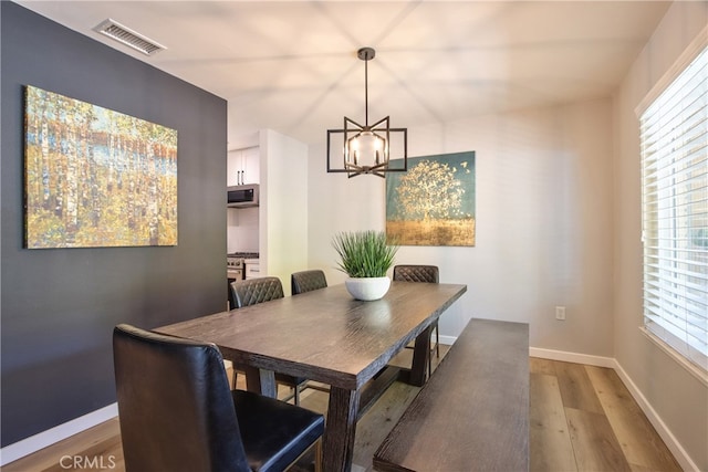 27071 Crews Hill Dr, Menifee, CA 92586 - dining area with light wood-type flooring, a chandelier, and baseboards