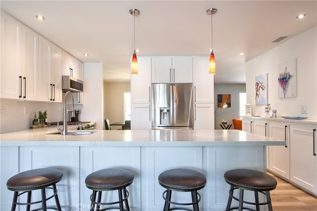 27071 Crews Hill Dr, Menifee, CA 92586 - kitchen featuring stainless steel appliances, a peninsula, white cabinets, decorative backsplash, and recessed lighting