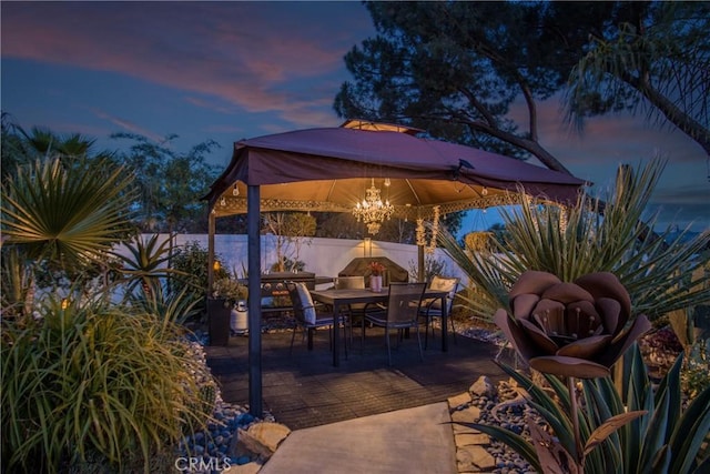 27071 Crews Hill Dr, Menifee, CA 92586 - patio terrace at dusk with outdoor dining space, a gazebo, and a fenced backyard