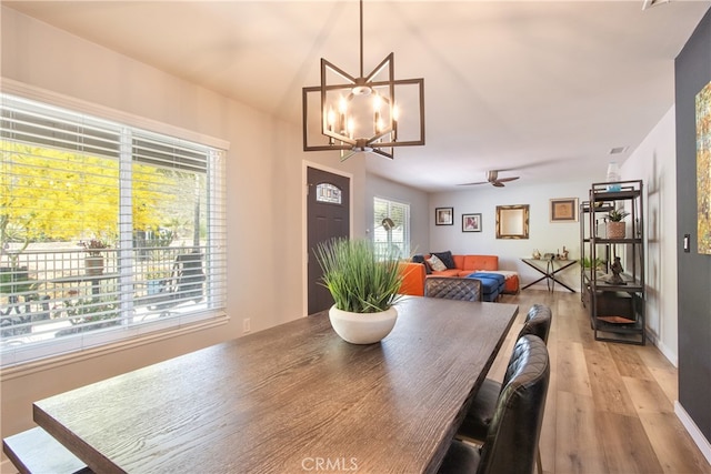 27071 Crews Hill Dr, Menifee, CA 92586 - dining area featuring a wood stove, light wood finished floors, a chandelier, and a ceiling fan