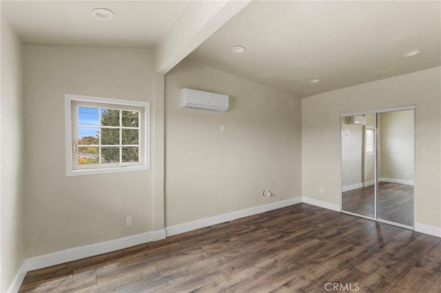 10010 S San Pedro St, Los Angeles, CA 90003 - unfurnished bedroom featuring a wall mounted air conditioner, dark wood-style flooring, baseboards, a closet, and recessed lighting