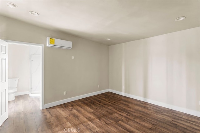 10010 S San Pedro St, Los Angeles, CA 90003 - empty room with a wall unit AC, dark wood-style floors, baseboards, and recessed lighting