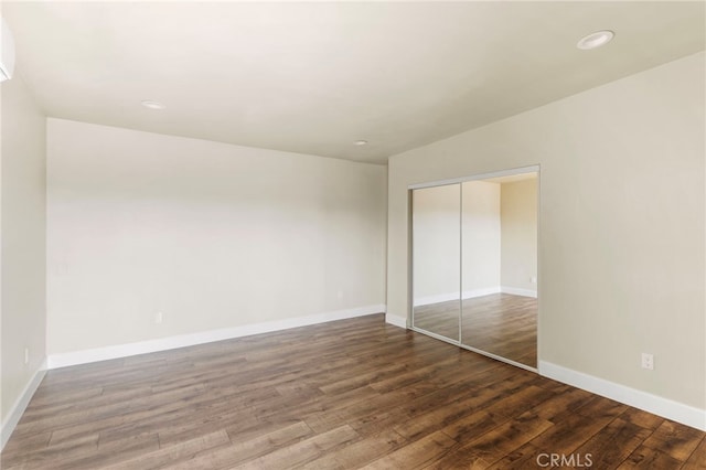 10010 S San Pedro St, Los Angeles, CA 90003 - unfurnished bedroom with a closet, wood finished floors, baseboards, and recessed lighting
