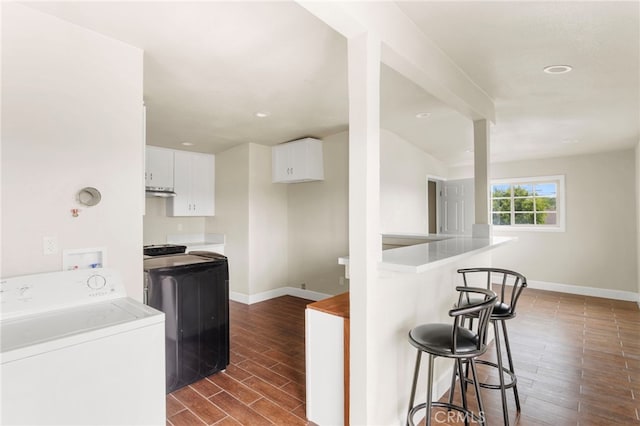 10010 S San Pedro St, Los Angeles, CA 90003 - kitchen with washer / dryer, dark wood-style flooring, white cabinets, a kitchen bar, and recessed lighting