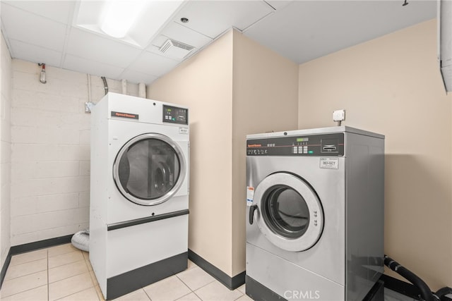 121 S Hope St Unit 9, Los Angeles, CA 90012 - community laundry room featuring washer / dryer, baseboards, light tile patterned floors, and concrete block wall