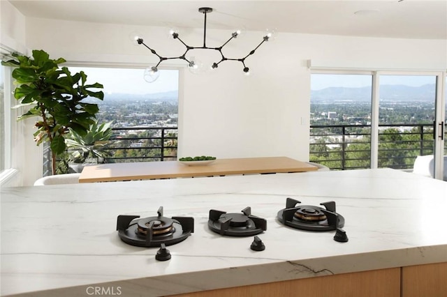 3863 Sherwood Pl, Sherman Oaks, CA 91423 - detailed view of a chandelier, a mountainous background, and light stone countertops