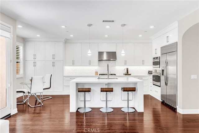 28181 Via Del Mar, San Juan Capistrano, CA 92675 - kitchen with stainless steel appliances, under cabinet range hood, tasteful backsplash, a breakfast bar area, and light countertops