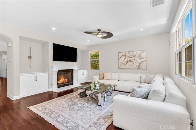 28181 Via Del Mar, San Juan Capistrano, CA 92675 - living area featuring dark wood-style flooring, ceiling fan, arched walkways, a glass covered fireplace, and recessed lighting