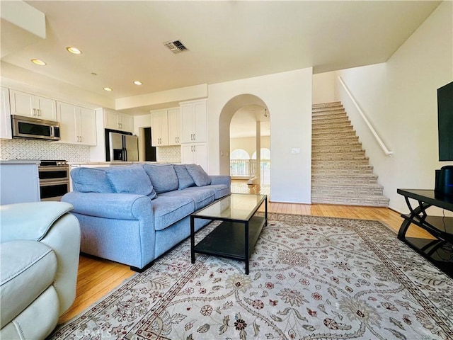 700 Meyer Ln, Redondo Beach, CA 90277 - living area with arched walkways, light wood-style flooring, stairs, and recessed lighting