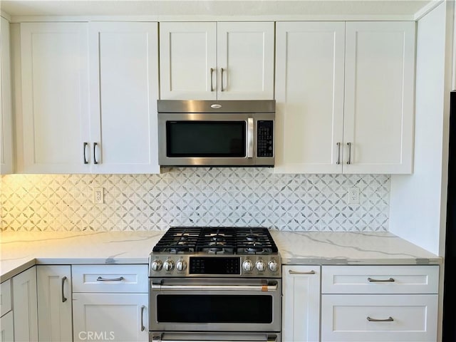 700 Meyer Ln, Redondo Beach, CA 90277 - kitchen with stainless steel appliances, white cabinetry, light stone counters, and decorative backsplash