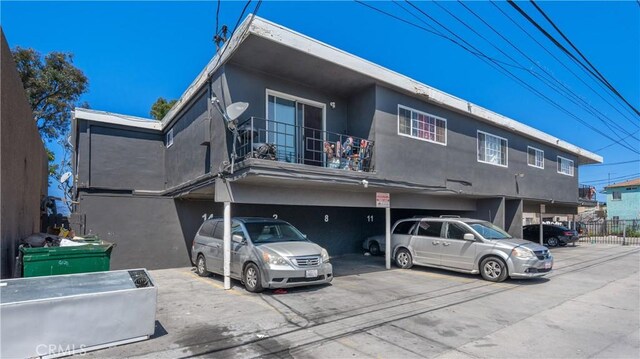 1850 Gardenia Ave, Long Beach, CA 90806 - view of front of home with a balcony, covered parking, and stucco siding