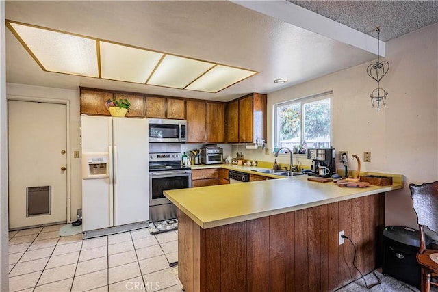 28030 Northwood Dr, Menifee, CA 92586 - kitchen featuring stainless steel appliances, a sink, a peninsula, brown cabinets, and light countertops