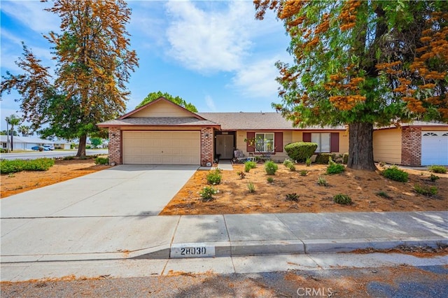 28030 Northwood Dr, Menifee, CA 92586 - ranch-style home with brick siding, an attached garage, and concrete driveway