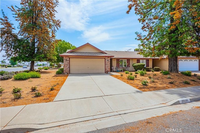 28030 Northwood Dr, Menifee, CA 92586 - ranch-style house featuring an attached garage, driveway, and brick siding