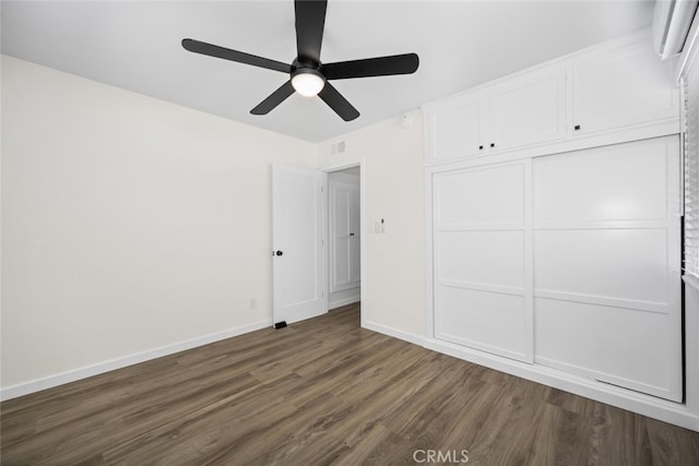 6082 Bannock Rd, Westminster, CA 92683 - unfurnished bedroom with an AC wall unit, dark wood-style floors, baseboards, ceiling fan, and a closet