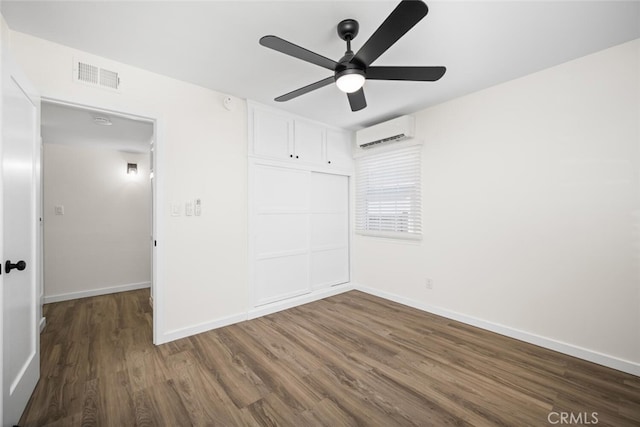 6082 Bannock Rd, Westminster, CA 92683 - unfurnished bedroom featuring an AC wall unit, dark wood-style floors, a closet, baseboards, and a ceiling fan