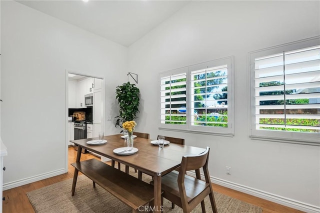 7612 Vicky Ave, West Hills, CA 91304 - dining room featuring plenty of natural light, baseboards, light wood-type flooring, and high vaulted ceiling