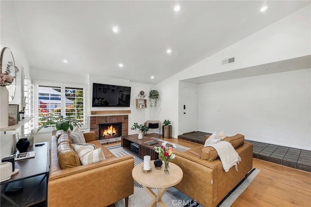 7612 Vicky Ave, West Hills, CA 91304 - living room featuring a brick fireplace, wood finished floors, lofted ceiling, and recessed lighting