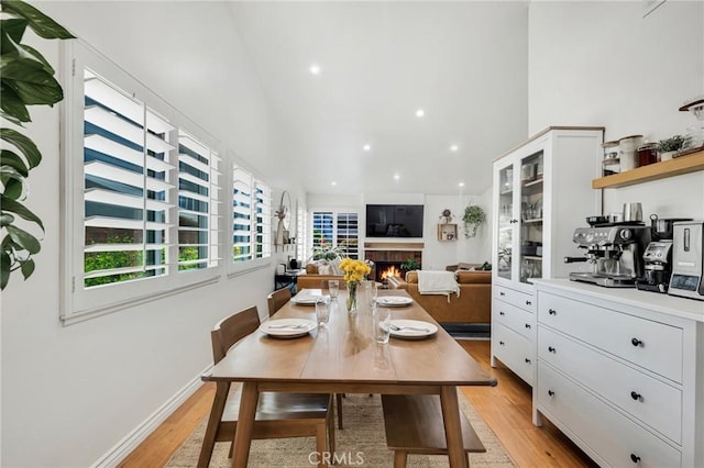 7612 Vicky Ave, West Hills, CA 91304 - dining space with high vaulted ceiling, light wood-style floors, a lit fireplace, and recessed lighting