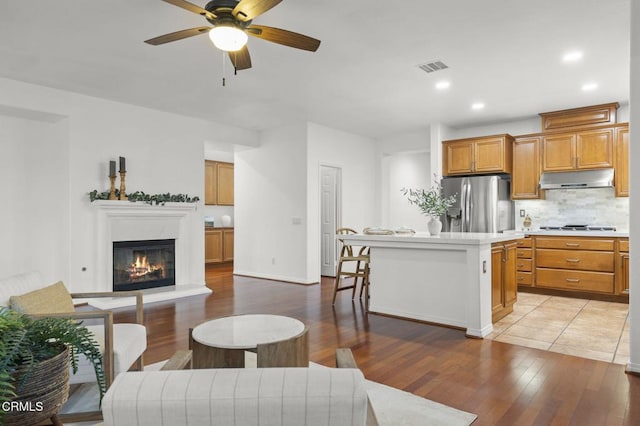 3806 Golden Pond Dr, Camarillo, CA 93012 - living area with light wood finished floors, a ceiling fan, recessed lighting, a glass covered fireplace, and baseboards