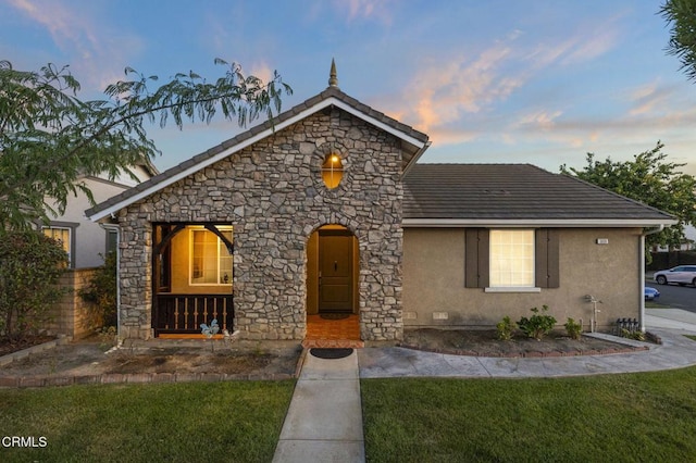 3806 Golden Pond Dr, Camarillo, CA 93012 - view of front facade featuring stucco siding, a front lawn, stone siding, and a porch