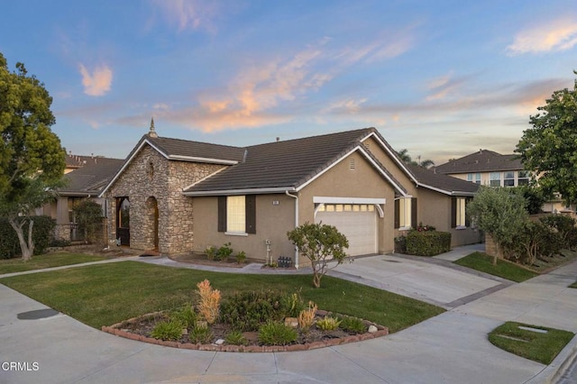 3806 Golden Pond Dr, Camarillo, CA 93012 - view of front facade with stone siding, a garage, stucco siding, concrete driveway, and a lawn
