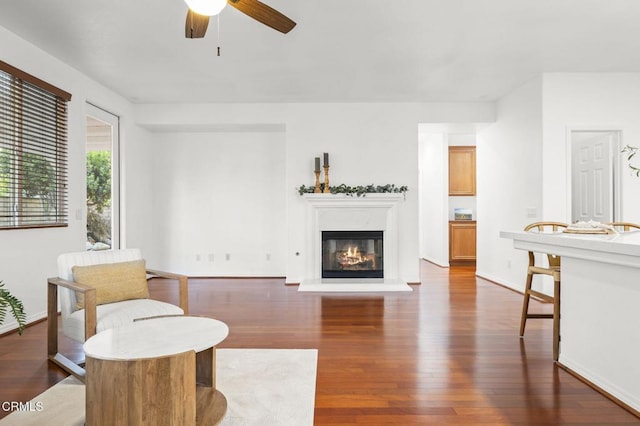 3806 Golden Pond Dr, Camarillo, CA 93012 - living room with dark wood-style floors, a ceiling fan, a glass covered fireplace, and baseboards
