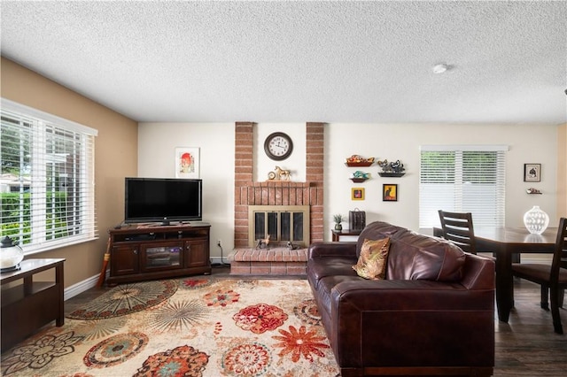 454 E Merrimac St, Upland, CA 91784 - living room featuring a textured ceiling, a fireplace, baseboards, and wood finished floors