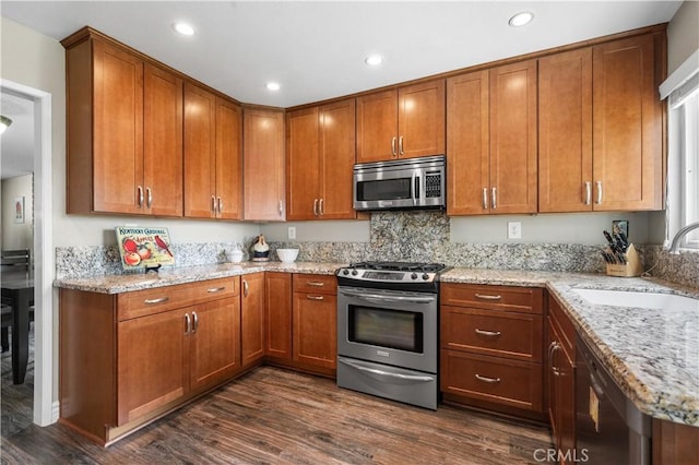 454 E Merrimac St, Upland, CA 91784 - kitchen featuring stainless steel appliances, a sink, dark wood-type flooring, light stone countertops, and brown cabinetry
