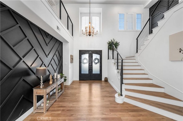 2229 N 3rd Ave, Upland, CA 91784 - entrance foyer with stairs, a chandelier, light wood-style floors, a high ceiling, and french doors