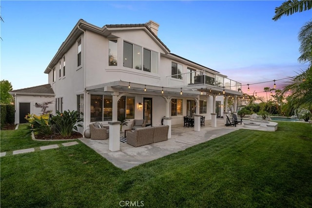 2229 N 3rd Ave, Upland, CA 91784 - back of property at dusk featuring an outdoor living space, stucco siding, a lawn, and a balcony