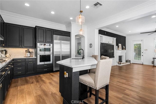 2229 N 3rd Ave, Upland, CA 91784 - kitchen featuring stainless steel appliances, a sink, open floor plan, wood finished floors, and recessed lighting