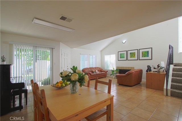 9009 Buckles St, Downey, CA 90241 - dining room with light tile patterned flooring, stairs, vaulted ceiling, and a fireplace