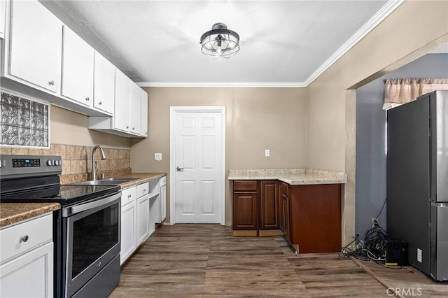 7791 Sherwood Blvd, Los Molinos, CA 96055 - kitchen with freestanding refrigerator, stainless steel range with electric stovetop, a sink, ornamental molding, and backsplash