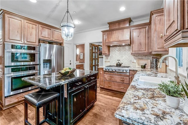 638 Sierra Madre Blvd Unit D, Sierra Madre, CA 91024 - kitchen with appliances with stainless steel finishes, light stone countertops, crown molding, a sink, and a center island