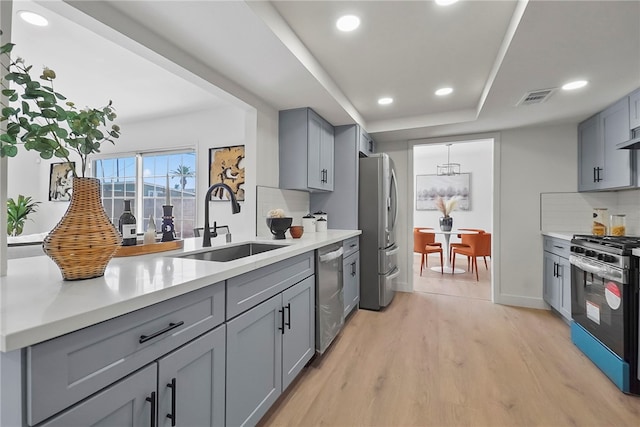 623 S Homerest Ave, Azusa, CA 91702 - kitchen featuring appliances with stainless steel finishes, gray cabinetry, a sink, light wood-style floors, and recessed lighting