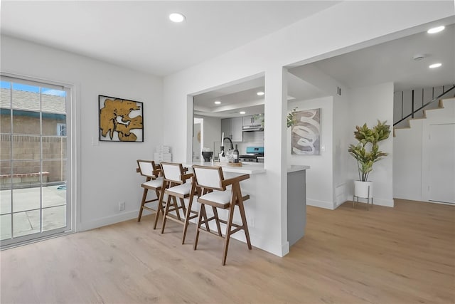 623 S Homerest Ave, Azusa, CA 91702 - kitchen with light wood-style flooring, a breakfast bar, recessed lighting, stainless steel range oven, and baseboards