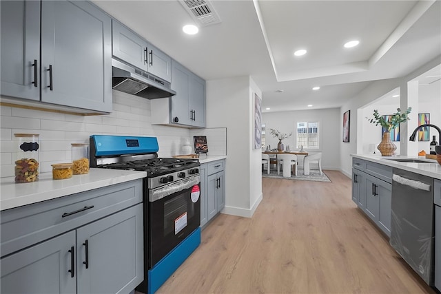 623 S Homerest Ave, Azusa, CA 91702 - kitchen with stainless steel appliances, under cabinet range hood, a sink, light wood-style floors, and light countertops