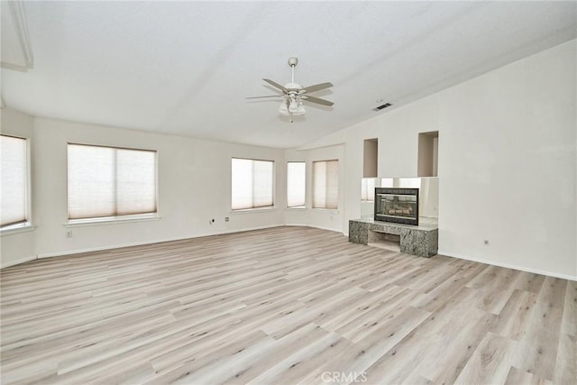 9920 Sage St, Oak Hills, CA 92344 - unfurnished living room featuring vaulted ceiling, light wood finished floors, a ceiling fan, a glass covered fireplace, and baseboards