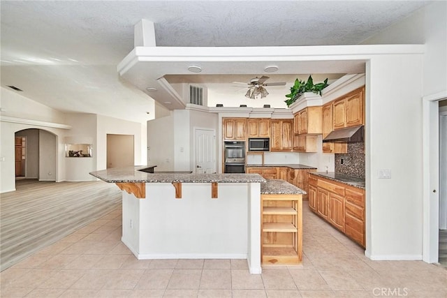 9920 Sage St, Oak Hills, CA 92344 - kitchen featuring black appliances, light tile patterned floors, arched walkways, a breakfast bar area, and ceiling fan