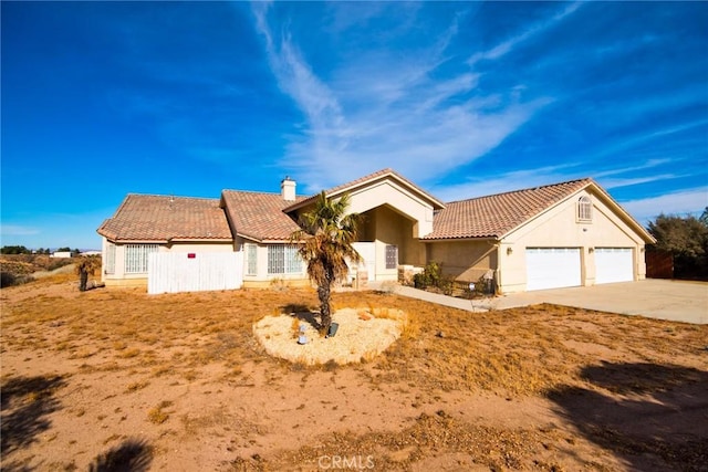 9920 Sage St, Oak Hills, CA 92344 - view of front of home featuring a chimney, a tiled roof, driveway, an attached garage, and stucco siding