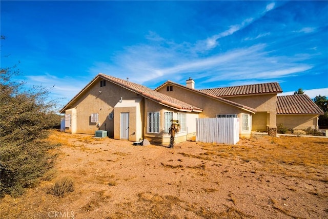 9920 Sage St, Oak Hills, CA 92344 - rear view of house with a chimney, stucco siding, central AC, and a tiled roof